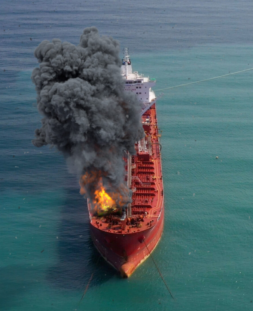 Aerial footage over Oil Tanker Ship Burning Under attack Aerial view with visual effect elements simulates realistic vision of Oil Tanker on fire with smoke in Gulf sea.